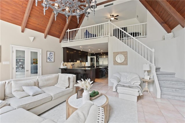 tiled living room with beamed ceiling, high vaulted ceiling, french doors, ceiling fan with notable chandelier, and wooden ceiling