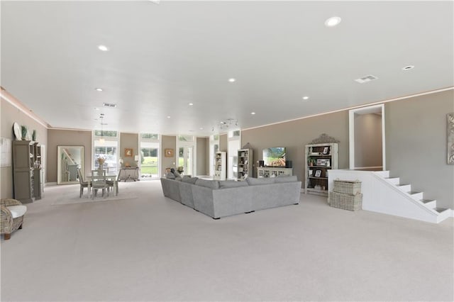 unfurnished living room featuring ornamental molding and light carpet