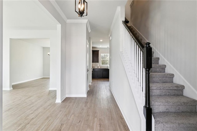 stairs with ornamental molding and hardwood / wood-style floors