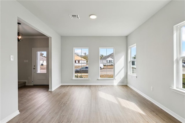 interior space featuring wood-type flooring, a wealth of natural light, and a notable chandelier