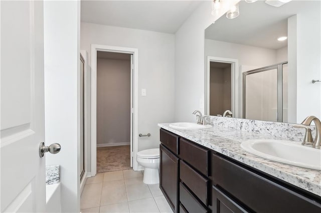 bathroom with tile patterned floors, an enclosed shower, vanity, and toilet