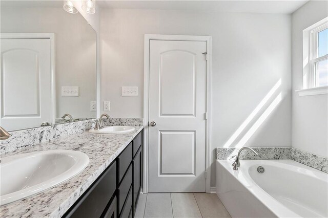 bathroom with a bathing tub, tile patterned floors, and vanity