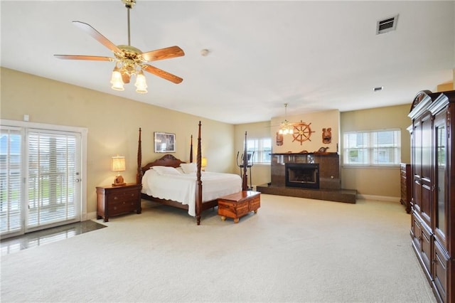 carpeted bedroom with ceiling fan, a fireplace, and access to outside