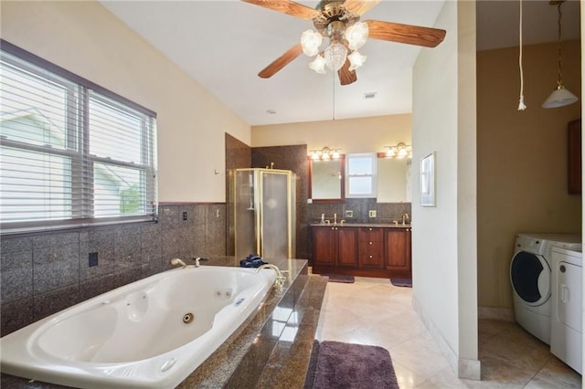 bathroom featuring vanity, plus walk in shower, tile patterned flooring, ceiling fan, and washing machine and dryer