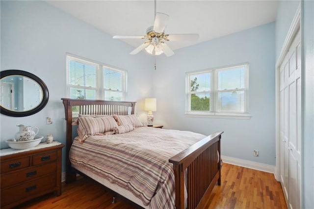 bedroom with ceiling fan, light hardwood / wood-style floors, and a closet