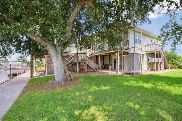 rear view of property with a yard and a wooden deck