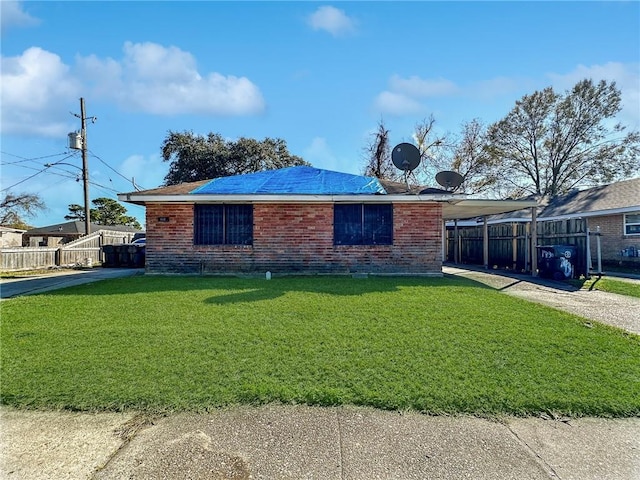 view of side of property featuring a carport and a lawn