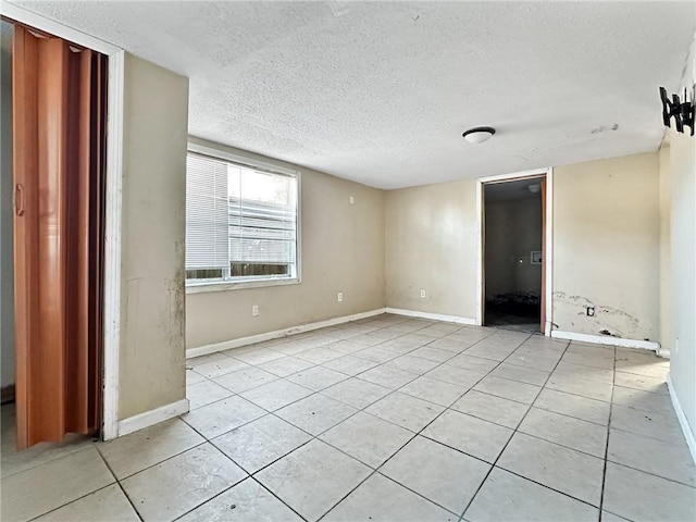 unfurnished bedroom featuring light tile patterned flooring and a textured ceiling