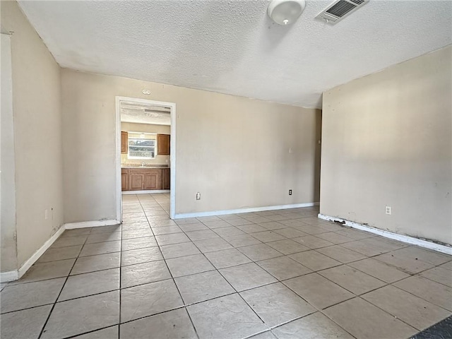 unfurnished room featuring light tile patterned floors and a textured ceiling