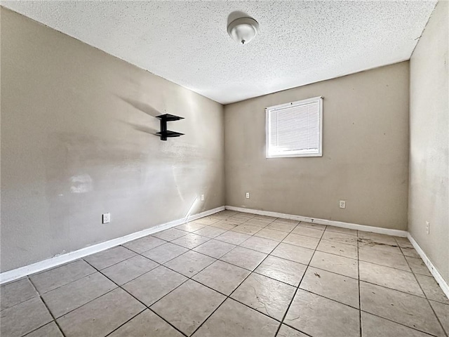 tiled spare room featuring a textured ceiling