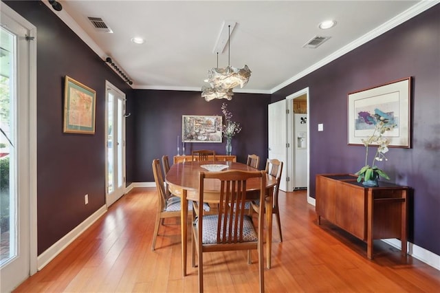 dining room with wood-type flooring, plenty of natural light, and ornamental molding