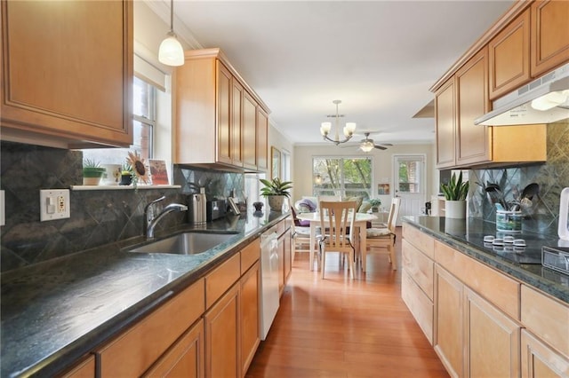 kitchen featuring sink, range hood, pendant lighting, decorative backsplash, and light wood-type flooring