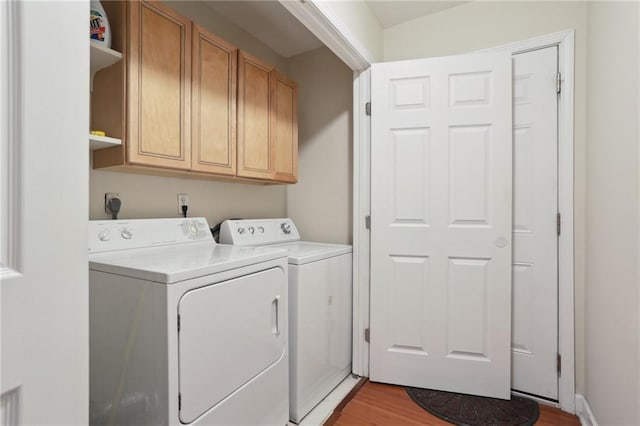 clothes washing area featuring cabinets, independent washer and dryer, and light hardwood / wood-style flooring