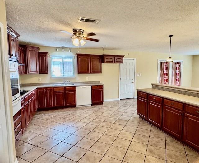 kitchen featuring wall oven, ceiling fan, sink, pendant lighting, and dishwasher