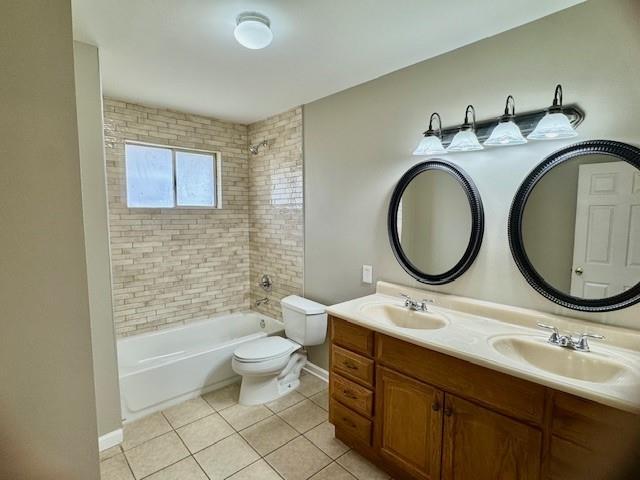 full bathroom with tile patterned flooring, vanity, toilet, and tiled shower / bath