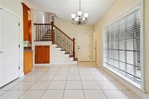 foyer with light tile patterned flooring, a wealth of natural light, and a chandelier