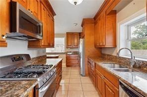 kitchen with sink, light tile patterned floors, and appliances with stainless steel finishes