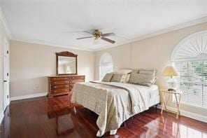 bedroom with crown molding, dark hardwood / wood-style flooring, and ceiling fan