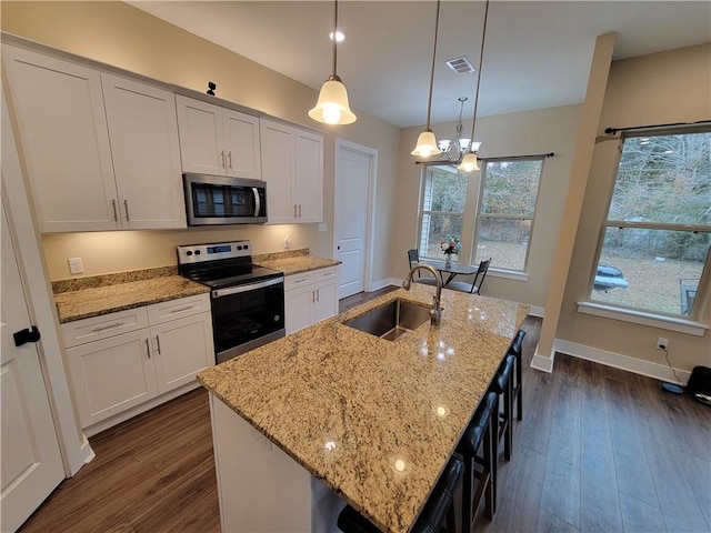 kitchen with stainless steel appliances, sink, a center island with sink, and white cabinets