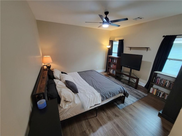 bedroom featuring multiple windows, hardwood / wood-style flooring, and ceiling fan