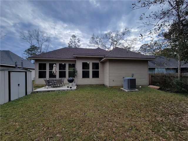 back of property with central AC, a storage shed, a patio area, and a lawn