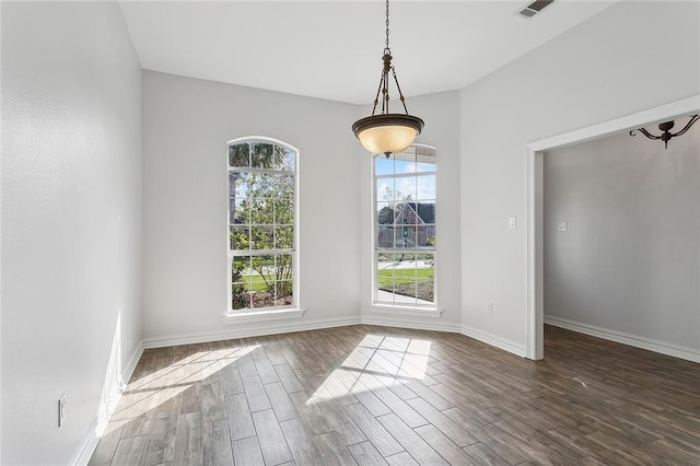 unfurnished dining area with visible vents, baseboards, and wood finished floors