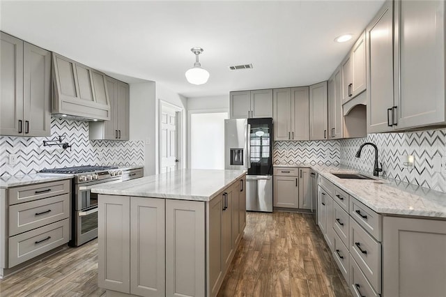 kitchen featuring visible vents, gray cabinets, a sink, dark wood finished floors, and appliances with stainless steel finishes