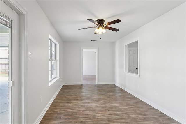 unfurnished room with visible vents, dark wood-style floors, baseboards, and ceiling fan