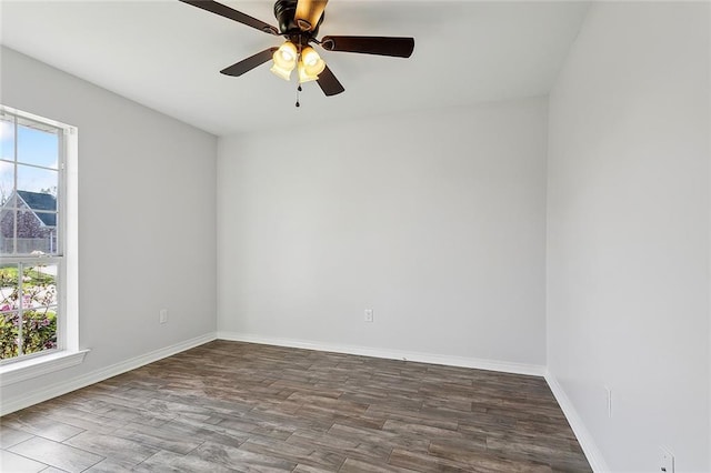 unfurnished room featuring wood finished floors, baseboards, and a wealth of natural light