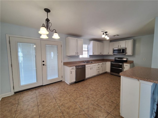 kitchen with decorative light fixtures, sink, an inviting chandelier, white cabinetry, and appliances with stainless steel finishes