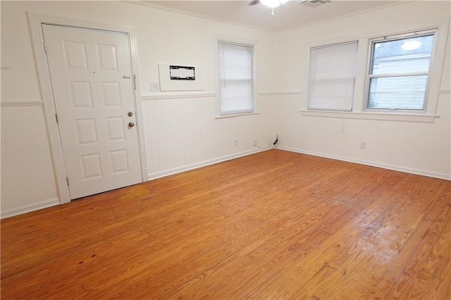 spare room with light hardwood / wood-style floors, ceiling fan, crown molding, and plenty of natural light