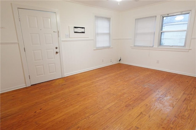 spare room featuring ornamental molding and light hardwood / wood-style floors