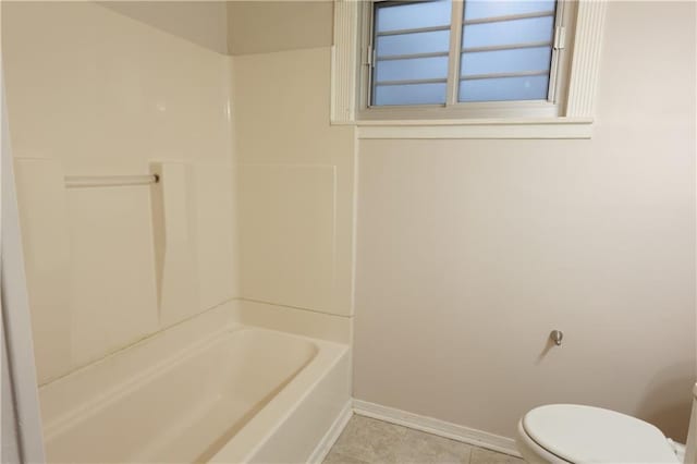 bathroom with toilet, tile patterned flooring, and washtub / shower combination