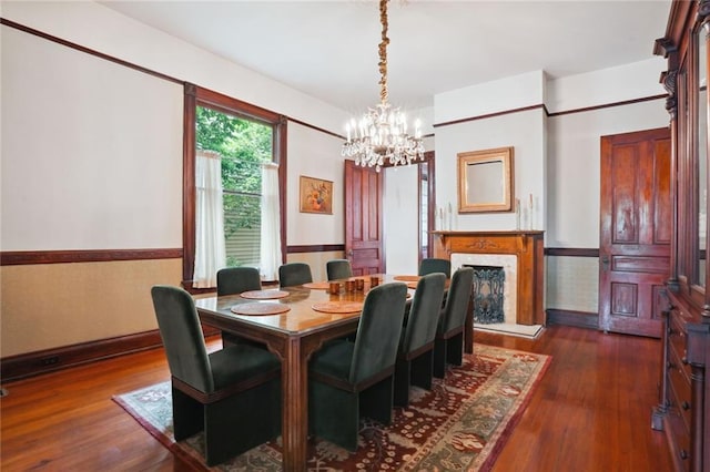 dining room featuring dark hardwood / wood-style flooring, a chandelier, and a fireplace