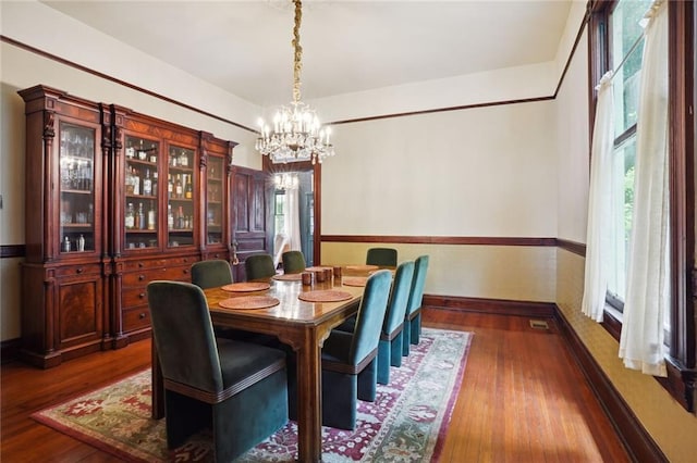 dining area featuring a notable chandelier and dark hardwood / wood-style floors