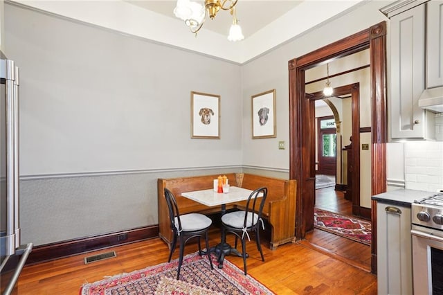 dining area with light hardwood / wood-style floors and a notable chandelier