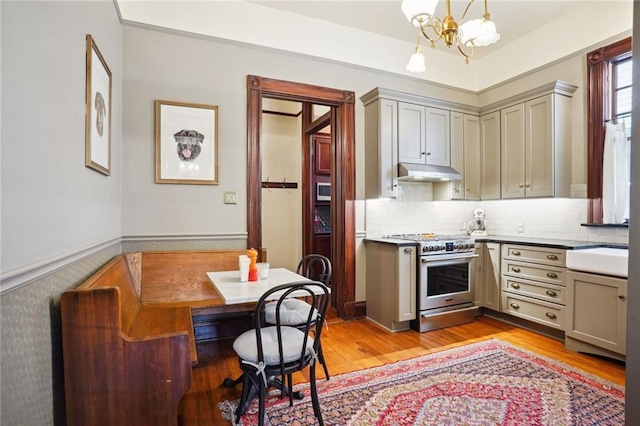 kitchen featuring decorative light fixtures, stainless steel range, light wood-type flooring, an inviting chandelier, and gray cabinetry