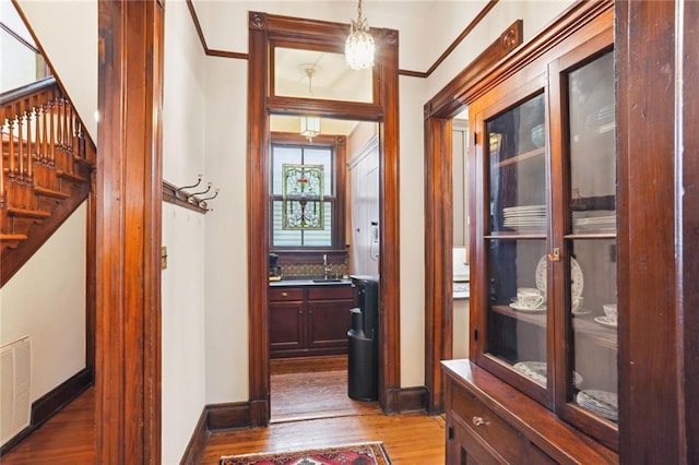 corridor featuring an inviting chandelier and light hardwood / wood-style floors