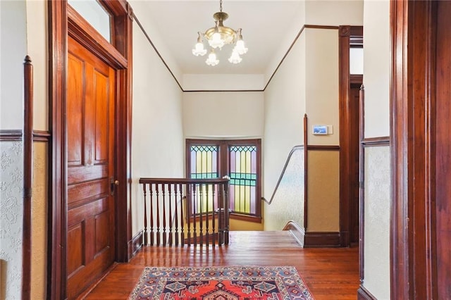 hallway with a notable chandelier and hardwood / wood-style floors