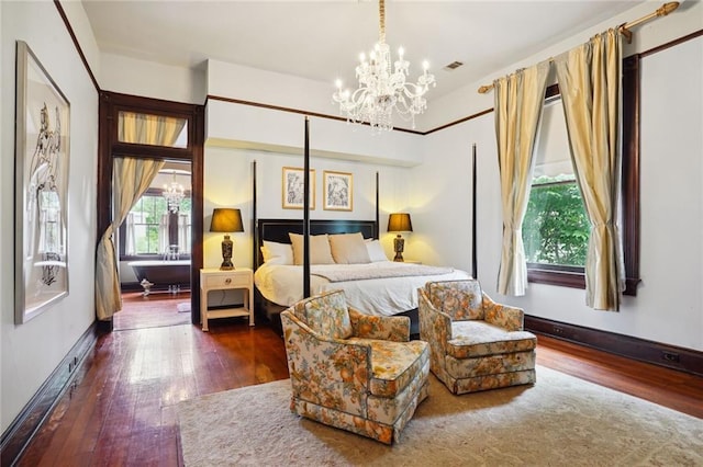 bedroom featuring dark hardwood / wood-style flooring and a notable chandelier