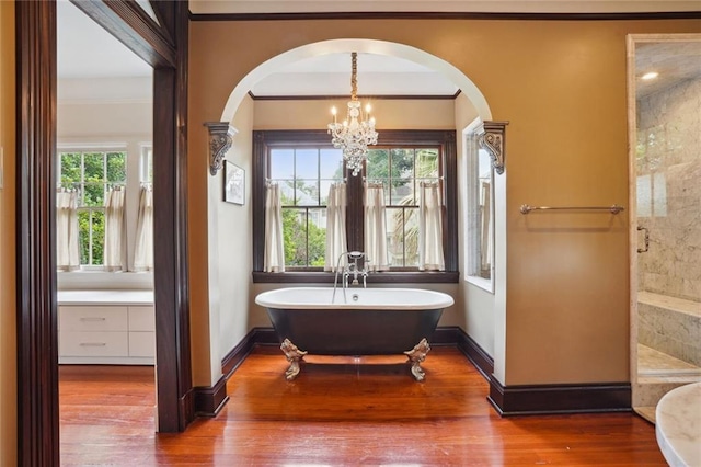 bathroom featuring a healthy amount of sunlight, independent shower and bath, a chandelier, and hardwood / wood-style flooring