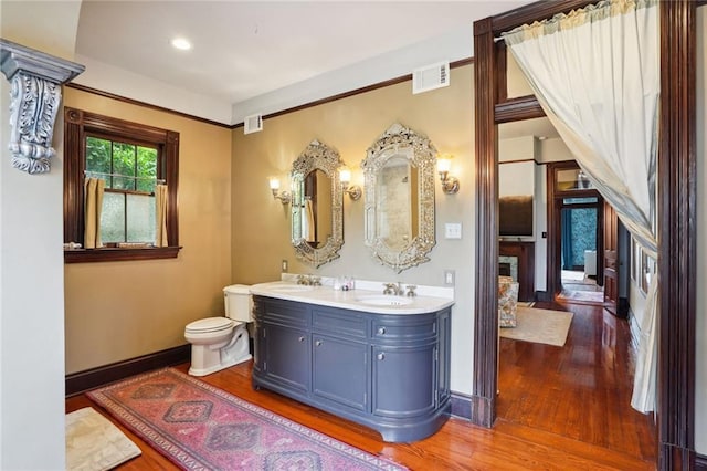 bathroom featuring toilet, vanity, and hardwood / wood-style floors