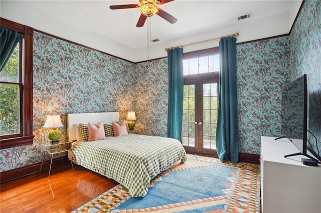 bedroom with french doors, ceiling fan, and hardwood / wood-style floors