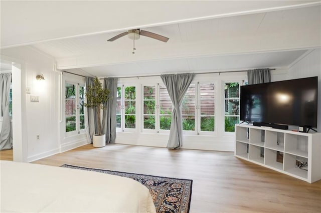 bedroom with beamed ceiling, ceiling fan, and wood-type flooring