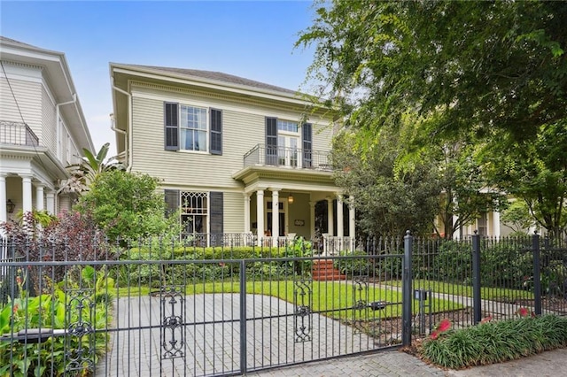 view of front of home featuring a balcony and a front lawn