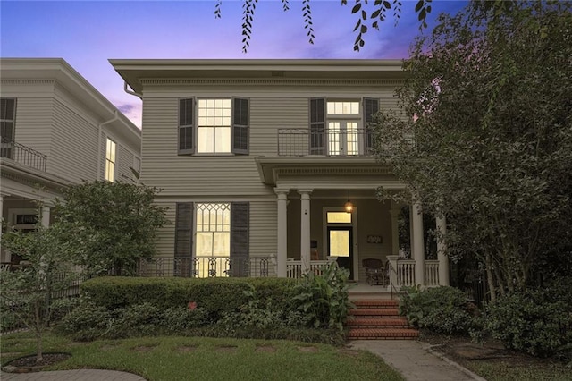 view of front of property featuring covered porch and a balcony