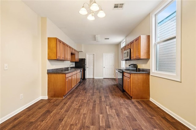 kitchen with sink, dark hardwood / wood-style flooring, black appliances, and a notable chandelier