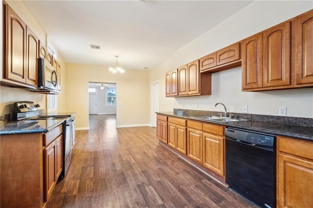 kitchen featuring appliances with stainless steel finishes, dark wood-type flooring, sink, decorative light fixtures, and ceiling fan with notable chandelier