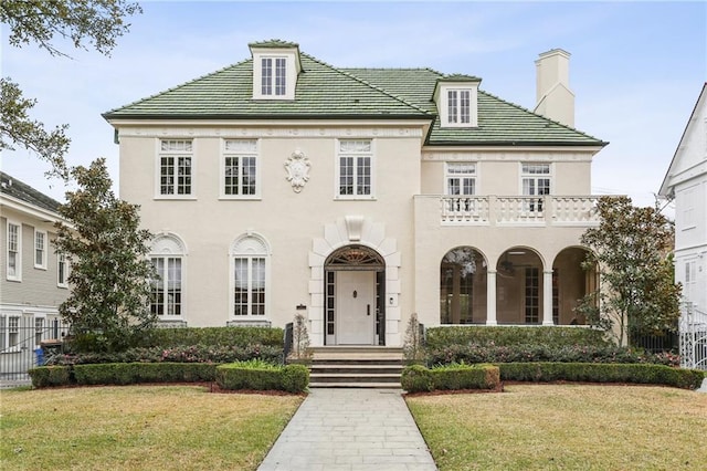 view of front of home featuring a front lawn and a balcony