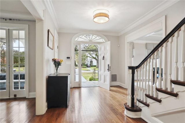 foyer with dark hardwood / wood-style flooring, crown molding, and french doors